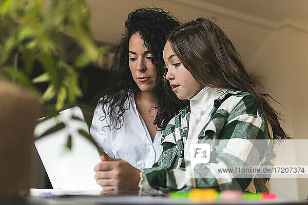 Mädchen bespricht sich mit ihrer Mutter beim E-Learning mit dem Laptop zu Hause