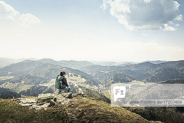 Female hiker looking at view while sitting on Kandel Mountain at Baden-Wurttemberg  Germany
