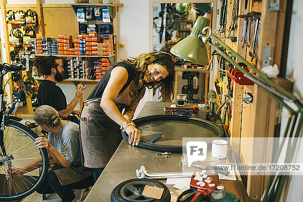 Männliche und weibliche Mechaniker reparieren Fahrrad in der Werkstatt