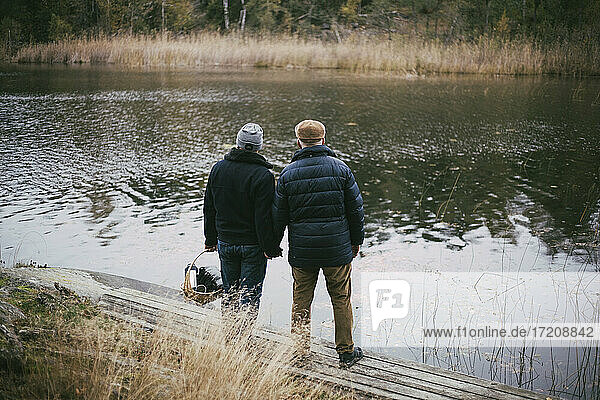 Rear view of gay couple admiring river while standing at riverbank