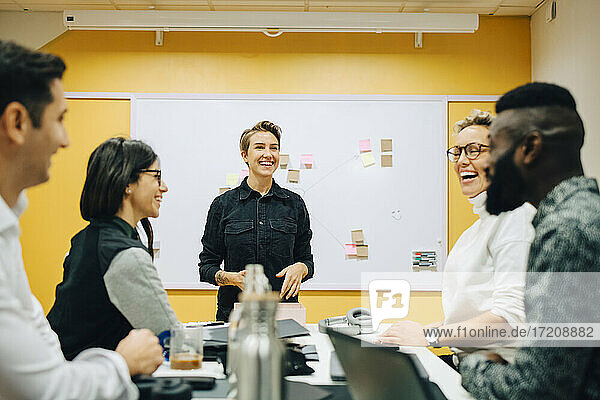 Geschäftsleute lachend während der Diskussion während der Sitzung im Sitzungssaal
