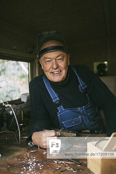 Porträt eines lächelnden männlichen Mechanikers in der Werkstatt