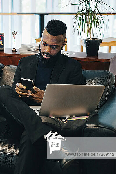Businessman using smart phone while working in office