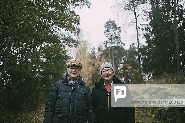 Porträt eines lächelnden homosexuellen Paares im Wald