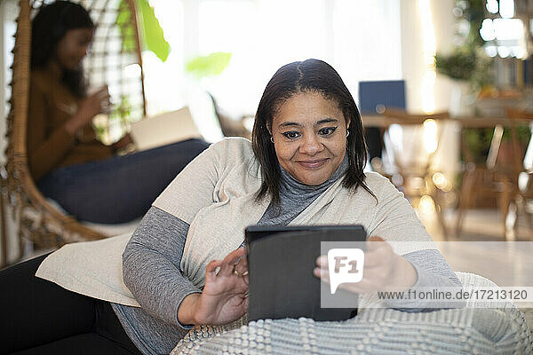 Frau verwendet digitales Tablet zu Hause