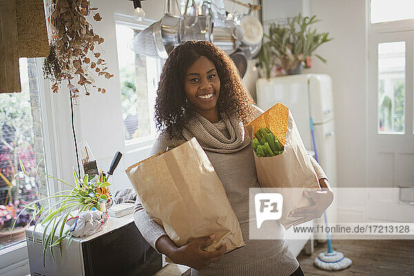 Porträt glückliche Frau mit Lebensmitteln in der Küche