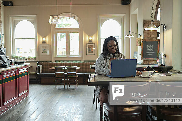 Geschäftsfrau arbeitet am Laptop im Café Tisch