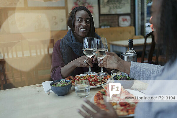 Mutter und Tochter genießen Wein und Pizza im Restaurant Mittagessen