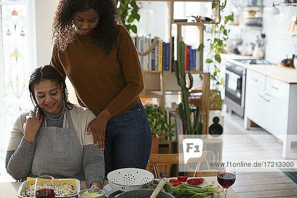 Mutter und Tochter kochen am Tisch in der Wohnung