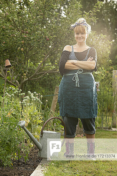 Portrait selbstbewusste Frau mit Gießkanne im Sommergarten