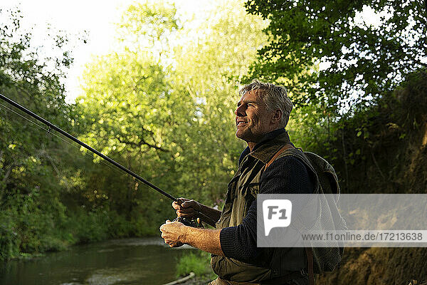 Serene man fly fishing at river