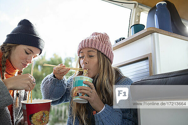Junge Frauen Freunde essen Instant-Nudeln im Wohnmobil