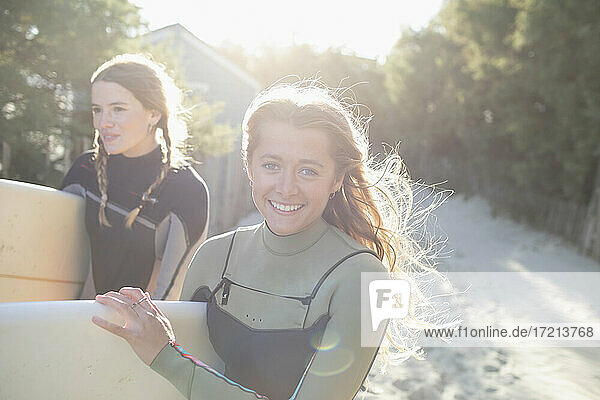 Porträt glücklich junge weibliche Surfer auf sonnigen Strand Weg