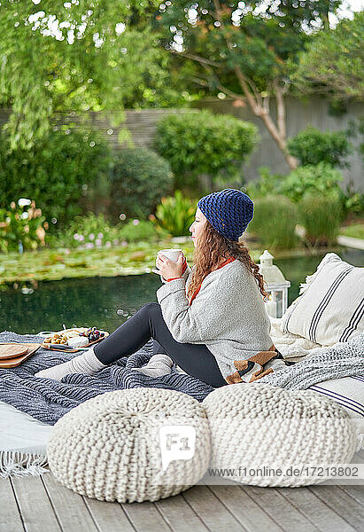 Serene Frau genießt Kaffee auf Luxus-Terrasse