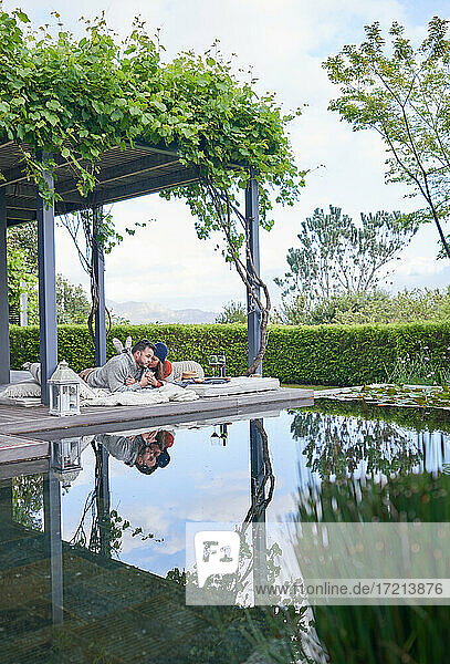 Zärtliches Paar entspannt auf Kissen auf der Terrasse eines Luxushotels