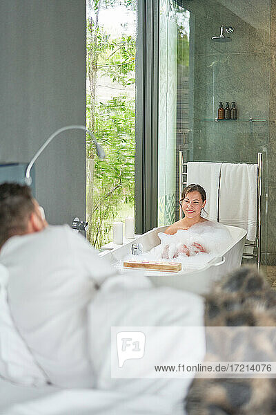 Paar nimmt Bad und liegt im Bett in Luxus modernen Hotelzimmer