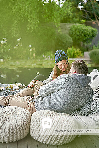 Zärtliches romantisches Paar entspannt sich auf Terrassen-Kissen