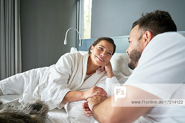 Happy affectionate couple relaxing on bed