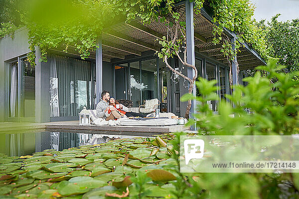 Zärtliches Paar entspannt mit Tee auf der Terrasse eines Luxushotels