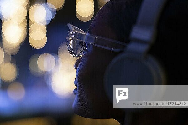 Close up junge Frau in funky Brille und Kopfhörer Blick auf Lichter