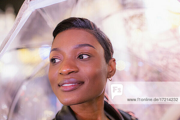 Close up schöne junge Frau mit kurzen schwarzen Haaren unter Regenschirm
