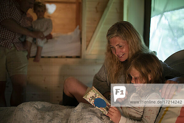 Mutter und Tochter lesen Schlafenszeit Geschichte Buch im Bett