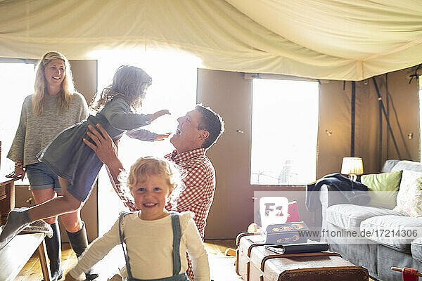 Happy family playing in sunny yurt cabin