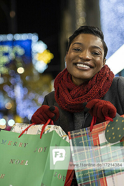 Porträt glückliche junge Frau mit Weihnachtseinkaufstaschen