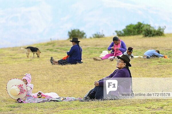 Old indigenous woman and granddaughter sitting in the grass  Quinua  Huamanga province  Peru  South America