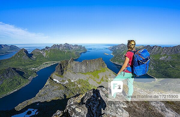 Hiker standing on top of Grytetippen  fjord and mountains  Senja  Norway  Europe