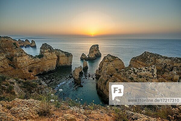 Schroffe Felsenküste mit Klippen aus Sandstein  Felsformationen im Meer  Ponta da Piedade  Morgenrot bei Sonnenaufgang  Algarve  Lagos  Portugal  Europa