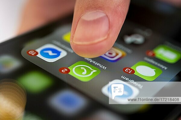 Finger tippt auf Bildschirm mit App Symbolen von Messenger-Diensten und sozialen Netzwerken  WhatsApp  Facebook  Telegram  Snapchat  Threema  iPhone 11 Pro  Smartphone