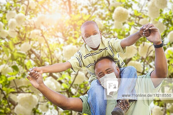 African American Father And Son Playing Outdoors Wearing Medical Face Mask