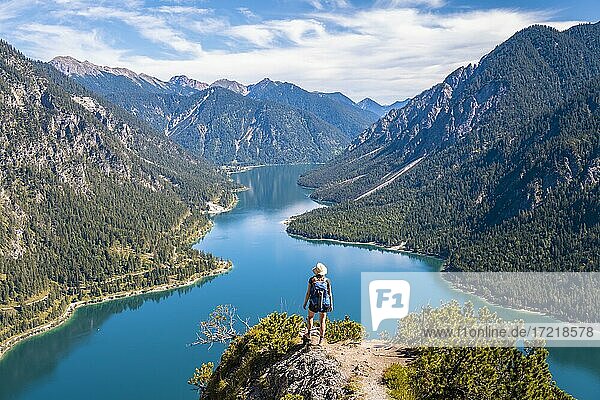 Hiker looking at Plansee  mountains with lake  Ammergau Alps  district Reutte  Tyrol  Austria  Europe