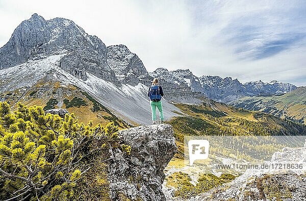 Wanderin auf einem Felsen  herbstliche Bäume  Wanderung zum Hahnkampl  links Gipfel der Lamsenspitze  Eng  Gemeinde Hinterriß  Karwendelgebirge  Alpenpark Karwendel  Tirol  Österreich  Europa