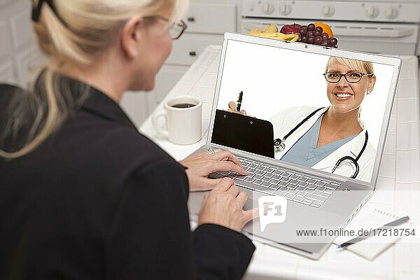 Frau in Küche mit Laptop  Online-Chat mit Krankenschwester oder Ärztin auf dem Bildschirm