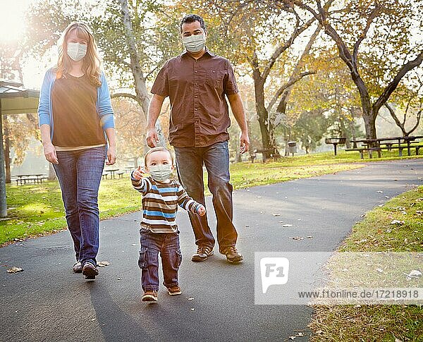Happy Mixed Race Ethnic Family Walking In The Park Wearing Medical Face Mask  USA  North America