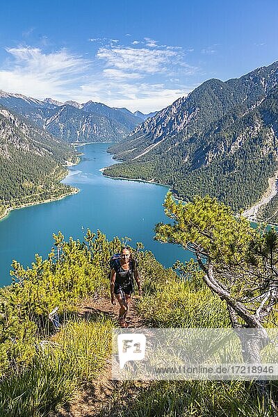 Hiker walking at Plansee  mountains with lake  Ammergau Alps  district Reutte  Tyrol  Austria  Europe