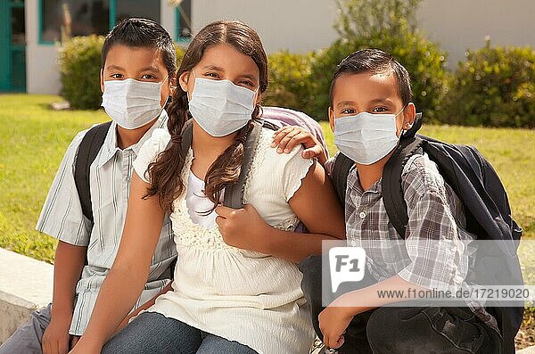 Junge hispanische Studenten auf dem Schulcampus  die medizinische Gesichtsmasken tragen  USA  Nordamerika