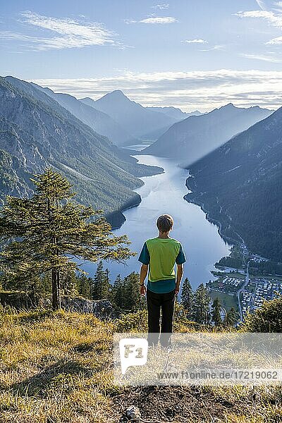 Hiker looks at Plansee  mountains with lake  Ammergau Alps  district Reutte  Tyrol  Austria (Hiker) looks at Plansee  mountains with lake  Ammergau Alps  district Reutte  Tyrol  Austria  Europe