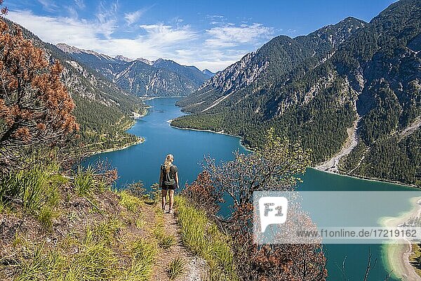 Hiker walking at Plansee  mountains with lake  Ammergau Alps  district Reutte  Tyrol  Austria  Europe