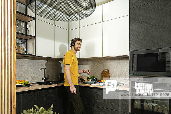 Mann hört Musik beim Kochen in der Küche zu Hause