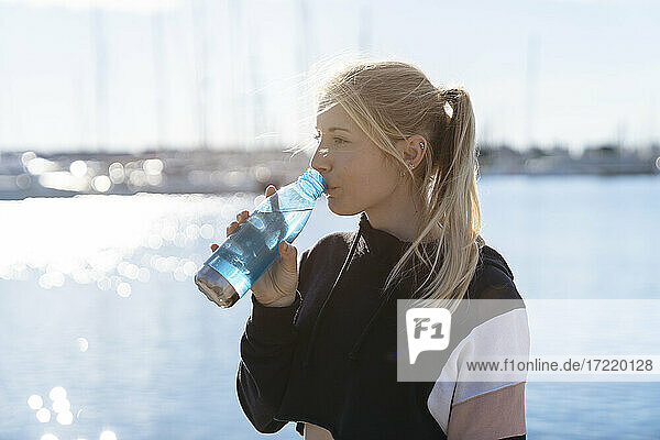 Junge blonde Frau trinkt Wasser