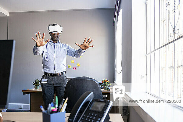 Male entrepreneur wearing Virtual reality headset in office
