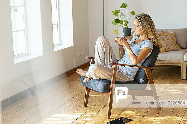 Frau in Loungewear beim Kaffee trinken zu Hause