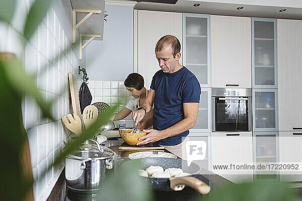 Ehepaar bereitet gemeinsam Essen in der Küche zu Hause vor