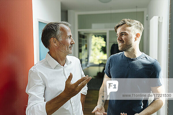 Vater und Sohn diskutieren  während sie zu Hause stehen