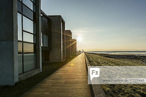 Dänemark  Romo  Uferpromenade entlang einer Reihe von modernen Sommerhäusern bei Sonnenuntergang
