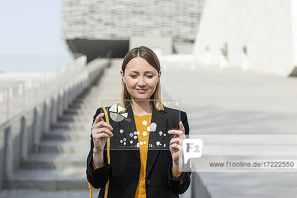 Businesswoman with futuristic digital tablet outdoors