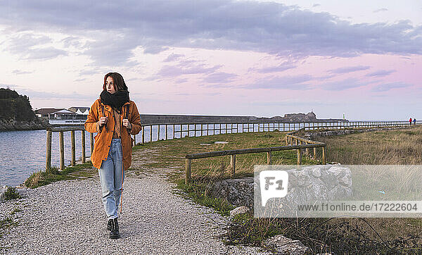 Spain  Cantabria  San Vicente de la Barquera  Young backpacker tourist enjoying sea coast at sunset